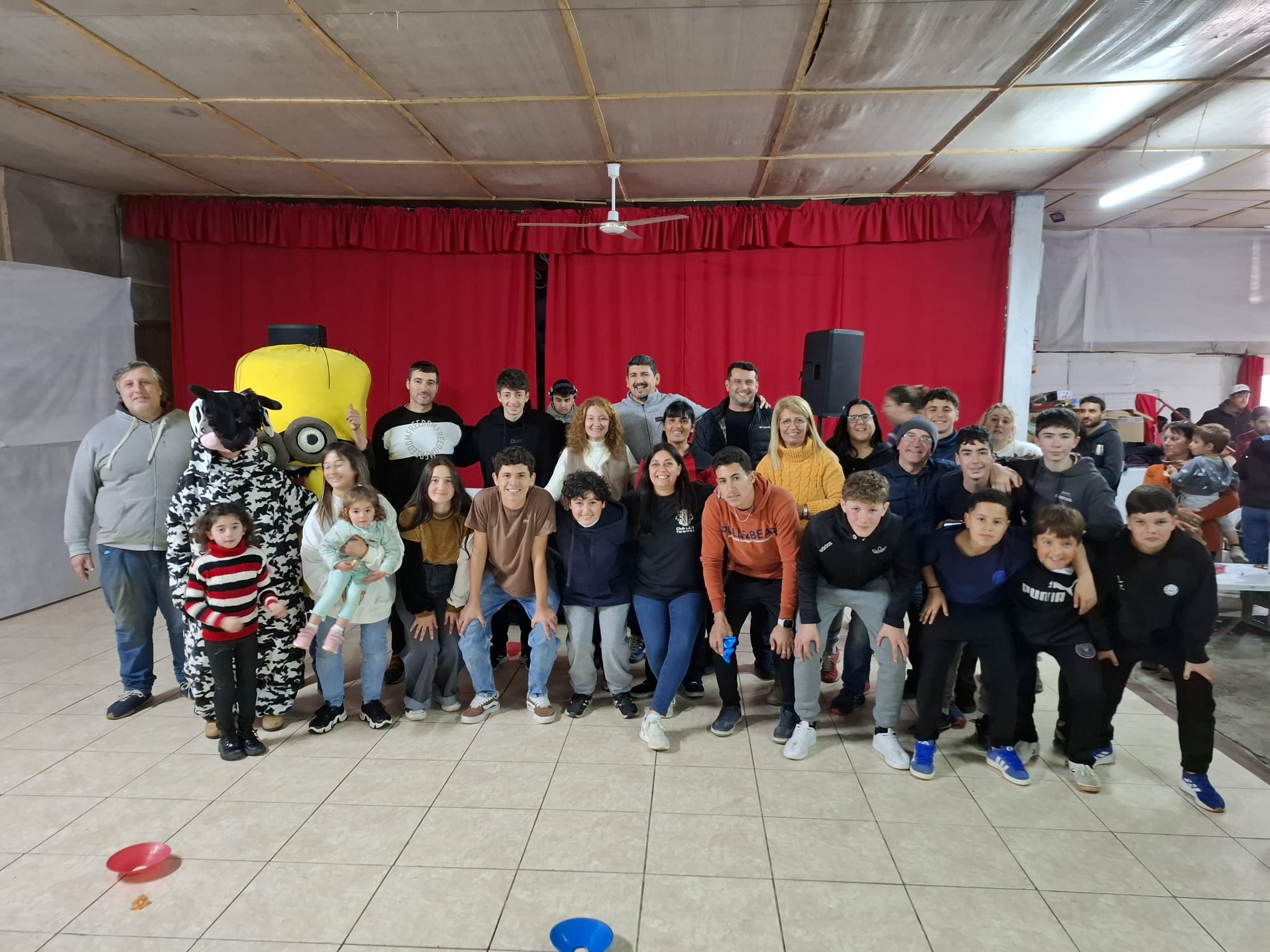 Equipo organizador y voluntariado posando en el escenario.